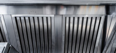 New clean stainless steel hood in professional kitchen close up